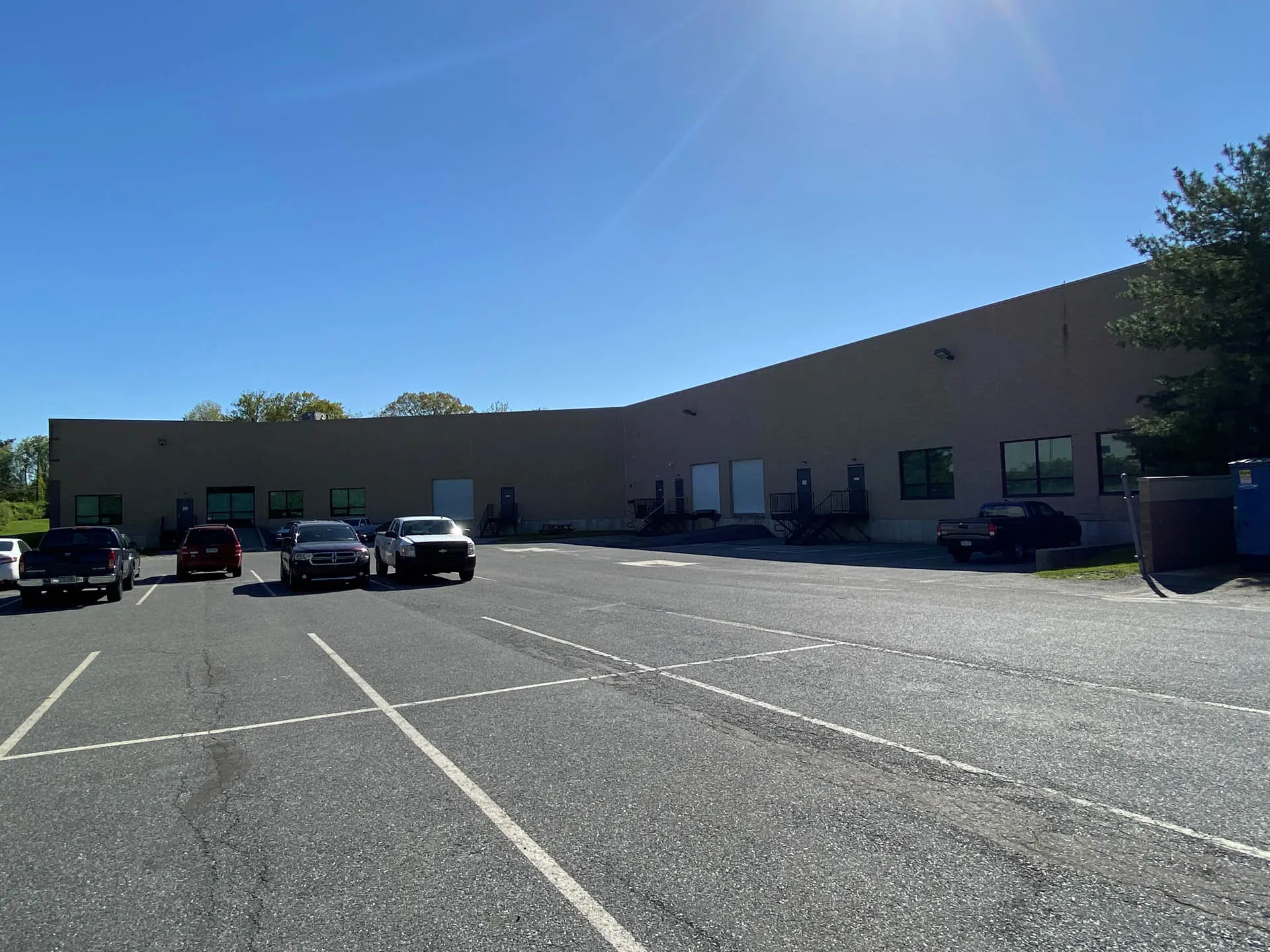 A large business warehouse with a big parking lot